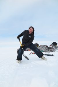 Ben Jones, co-author of the new study, shoveling snow off of a lake before drilling a hole in the ice. Credit: Christopher Arp, University of Alaska Fairbanks. 