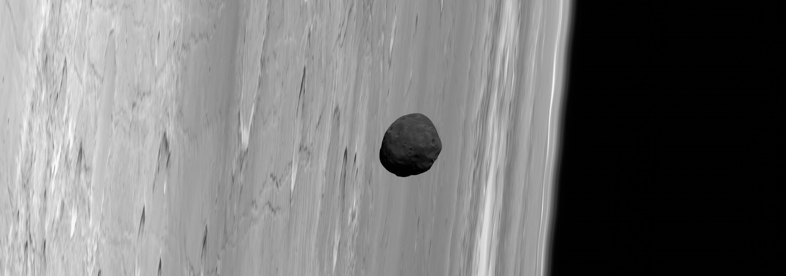 Phobos, the larger of Mars’ two tiny satellites, is the darkest moon in the solar system. This dark aspect inspired the hypothesis that the close-orbiting moon may be a captured asteroid, but its orbital dynamics seemed to disagree. A new study suggests Phobos’ composition may be more like the volcanic crust of the Red Planet than it appears, consistent with an origin for the moon in an ancient, violent impact on Mars. Credit: G. Neukum (FU Berlin) et al., Mars Express, DLR, ESA; Acknowledgement: Peter Masek