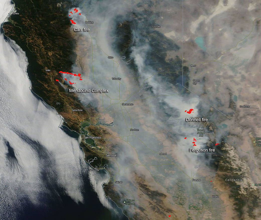 A satellite image, August 6, 2018, shows smoke from multiple large California wildfires. The fires themselves, detected by thermal imagery, are in red. Credit: NASA.