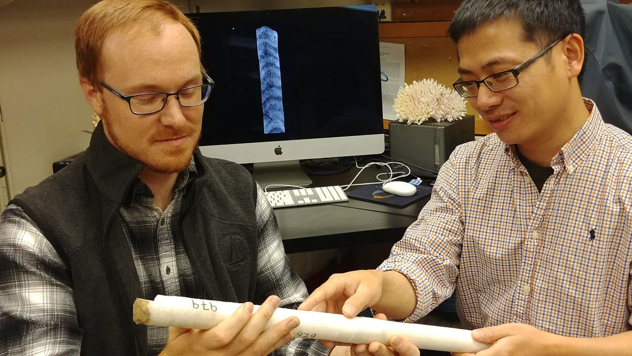 MIT-WHOI Joint Program student Nathaniel Mollica (left) and WHOI scientist Weifu Guo examine a core extracted from a coral skeleton. Credit: Anne Cohen Lab, ©Woods Hole Oceanographic Institution