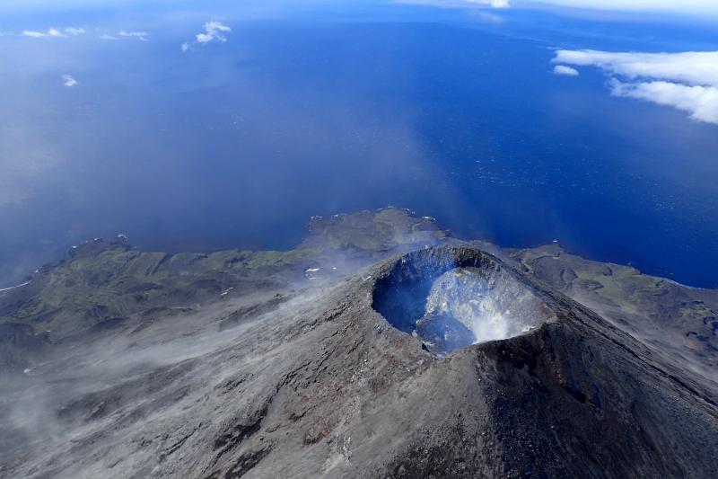 Mount Cleveland's summit crater emits a vigorous steam and gas plume. The small lave dome with a diameter of roughly 50 m is present within the summit crater. Credit: Cindy Werner/USGS. 