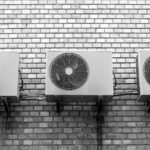 photograph of three AC units mounted on a brick wall