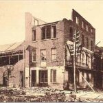 A faded photograph from 1886 depicting a damaged building after an earthquake.