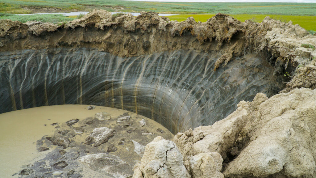 A large crater in the ground in the Siberian tundra.