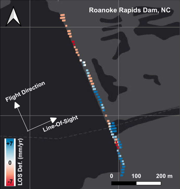 A map that shows the Roanoke dam in a straight line. The map is in black and gray, but along the map where the dam is in a line there are little colored dots. Along the north end of the dam the dots are light red, orange, and white. Along the southern half, the dots are dark blue and light blue with a few deep red clustered together.