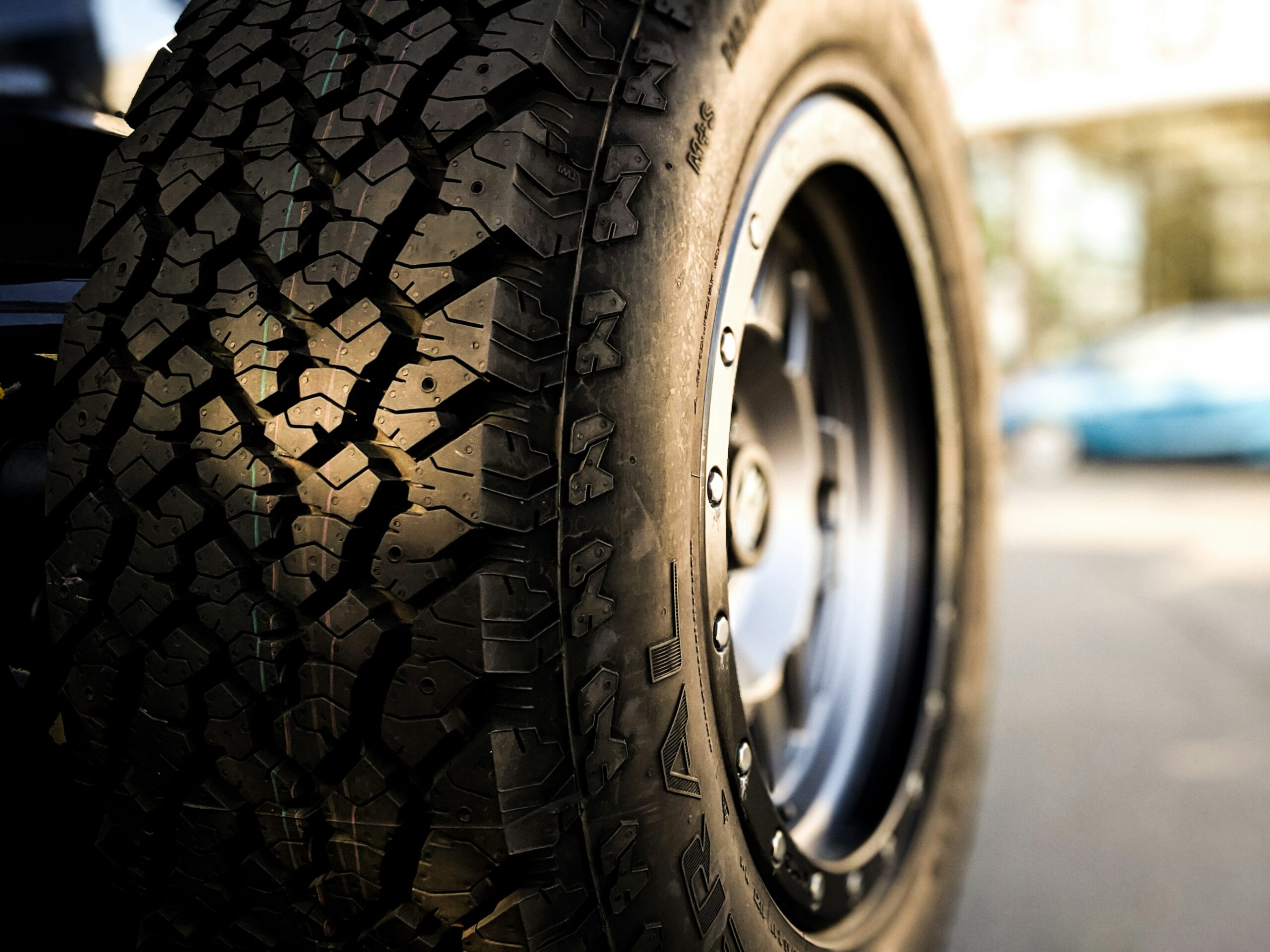 A single car tire illuminated with daylight from a side angle