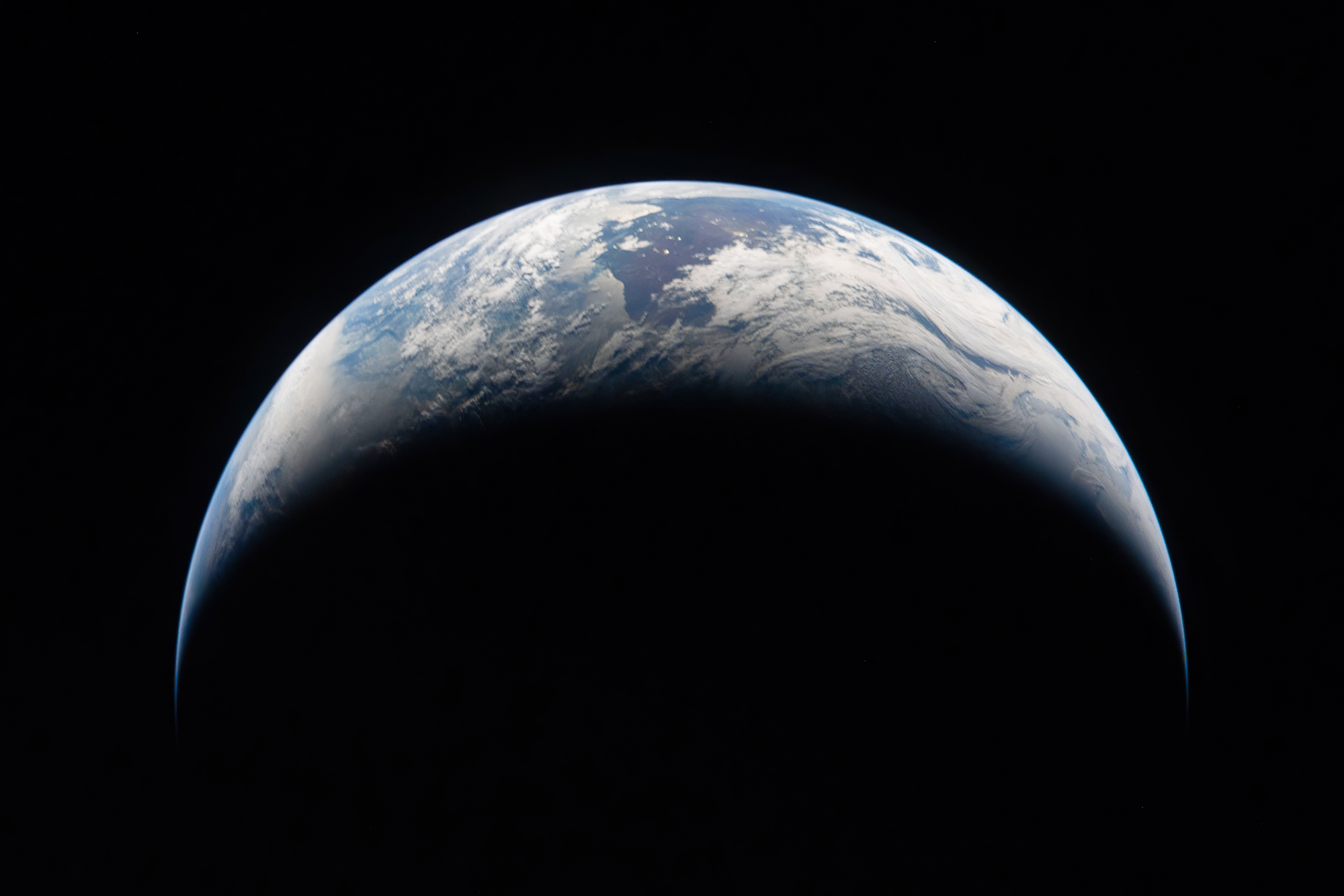 A crescent-shaped sliver of the Earth lit by sunlight against the blackness of space as seen from space by NASA's Artemis II lunar flyby in April 2026.